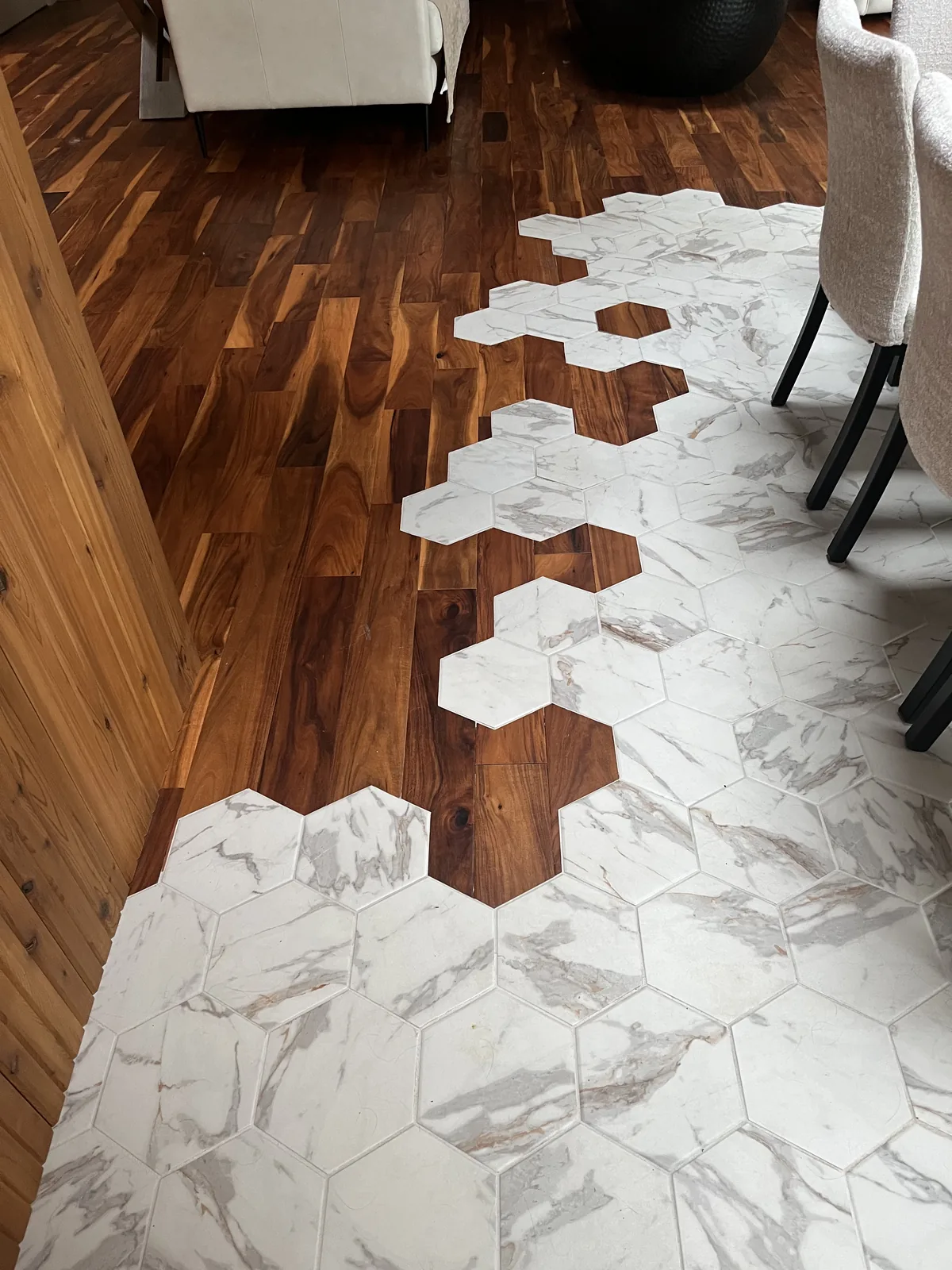 Hexagonal marble tile set into a hardwood floor at the transition between two rooms